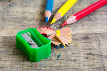 Sharpener and pencil shaves on wood with primary color pencils 