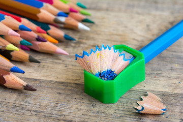 Sharpener and pencil shaves on wood with primary color pencils 