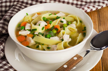 Bowl of chicken noodles soup  on a old wooden table.