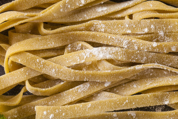 Fresh Pasta, close-up texture of Home made tagliatelle pasta flour ribbon noodle
