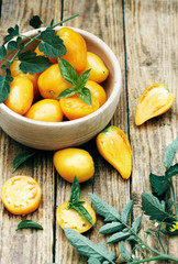 yellow tomatoes in a wooden bowl