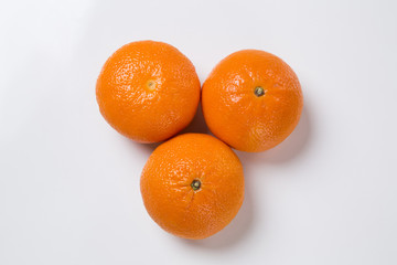Some tangerines in a basket over a wooden surface