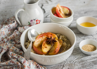oatmeal with caramelized apples and cinnamon in a white bowl on a light wooden background