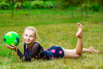 outdoor portrait of young cute little girl gymnast training with