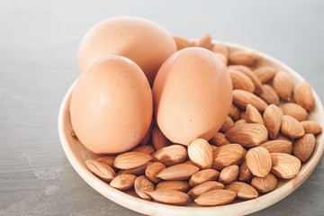 Almond nuts and eggs on wooden plate
