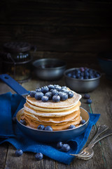 pancakes with blueberry and powdered sugar in pan