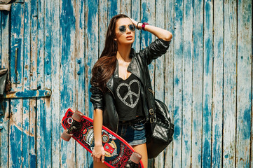 hipster girl posing with a skateboard outdoors © alex_shifer