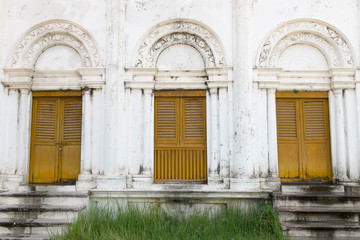 Yellow Wooden ancient door in an old white colored building in t