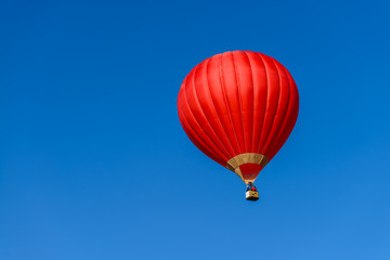 Naklejka premium Red hot air balloon in blue sky