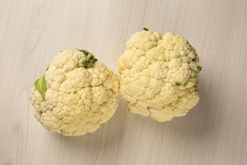 Obraz premium Some white cauliflowers over a wooden surface seen from above