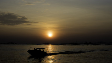Naklejka na ściany i meble Speed boat silhouette in sea with sunset sky