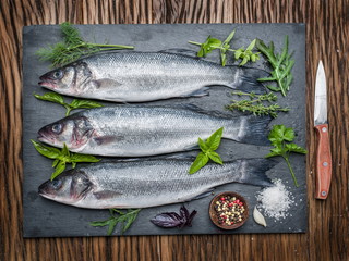 Seabass on a graphite board with spices and herbs.