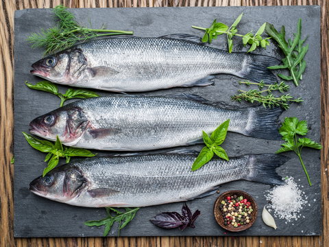 Seabass on a graphite board with spices and herbs.