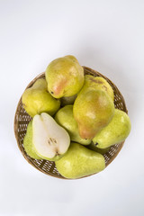 Some pears in a basket over a wooden surface seen from above