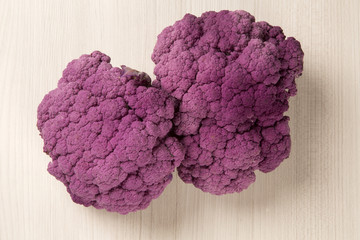 Some purple cauliflowers over a wooden surface seen from above