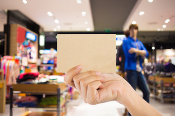 Photo blank. Hand hold blank business card in the shopping mall.