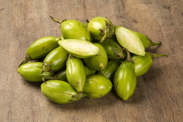 Some green african eggplants over a wooden surface