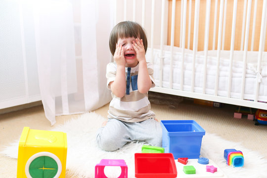Crying child scatters toys at home