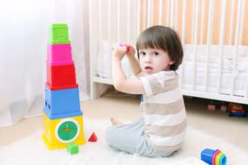 Cute little child plays educational toy at home