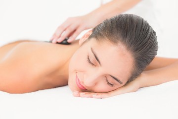 Beautiful brunette enjoying a hot stone massage 