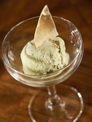scoop of pistachio ice cream. tasty homemade ice cream in a glass on dark background