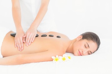 Fototapeta na wymiar Pretty woman enjoying a hot stone massage