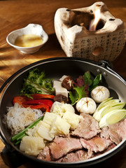 Sukiyaki dish. Slices veal fried with vegetables. Served with egg yolk and sauce