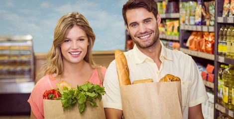 Portrait of smiling bright couple buying food products 