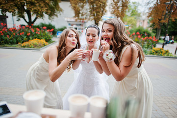 Young bridesmaid with bride drinking coffee