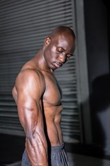 Fototapeta na wymiar Young Bodybuilder looking at his muscles