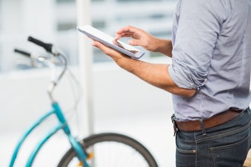 Businessman scrolling on his tablet in the office