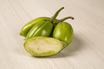 Some green african eggplants over a white background