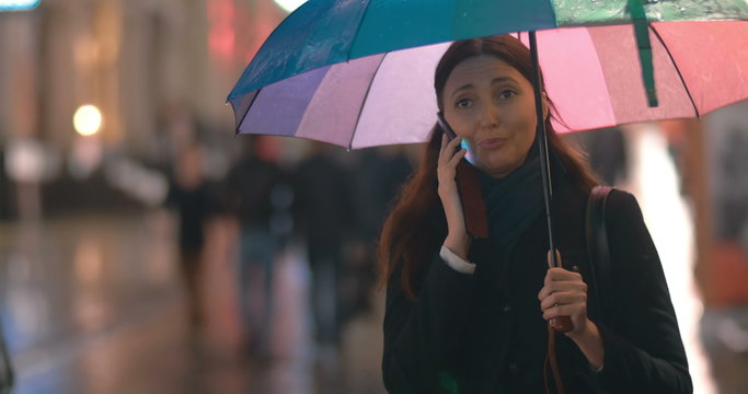 Young Woman With Umbrella Talking On The Phone 