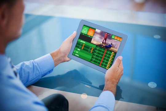 Composite image of businessman using his tablet 