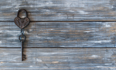 Heart and key on wooden background