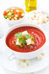fresh gazpacho in a white bowl, vertical, top view