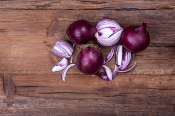 Red onions whole and chopped shot from above on a wooden background