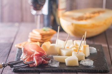 slices of cured ham with melon and red wine
