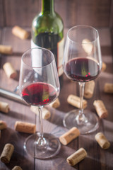 Red wine glasses, bottle and corks