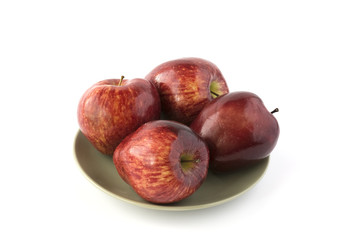 Red apples on a green dish