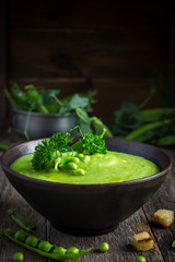 green pea soup on rustic background