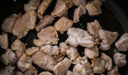 Fried meat with garlic on a pan. Selective focus with shallow depth of field.
