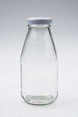 Empty colorless glass bottle on White Background