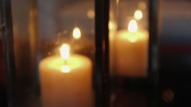 Burning candles inside box made of glass.
At first, a lack of focus and changing to focus on candles