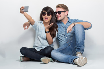 Mixed couple sitting on the floor taking self camera together