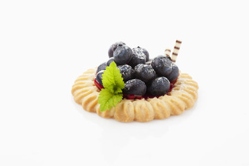 Obsttörtchen mit Blaubeeren, Puderzucker, Minzblatt