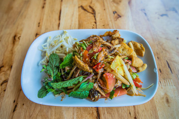 Som Tum (Thai Papaya Salas) on table.