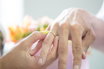 Naklejka premium bride dresses gold wedding ring on a finger to the groom
