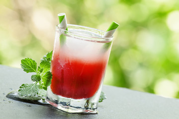 Frozen red cocktail with mint on the sun deck on a summer day, s