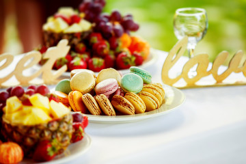 Closeup image of fresh fruits and berries and cookies at table